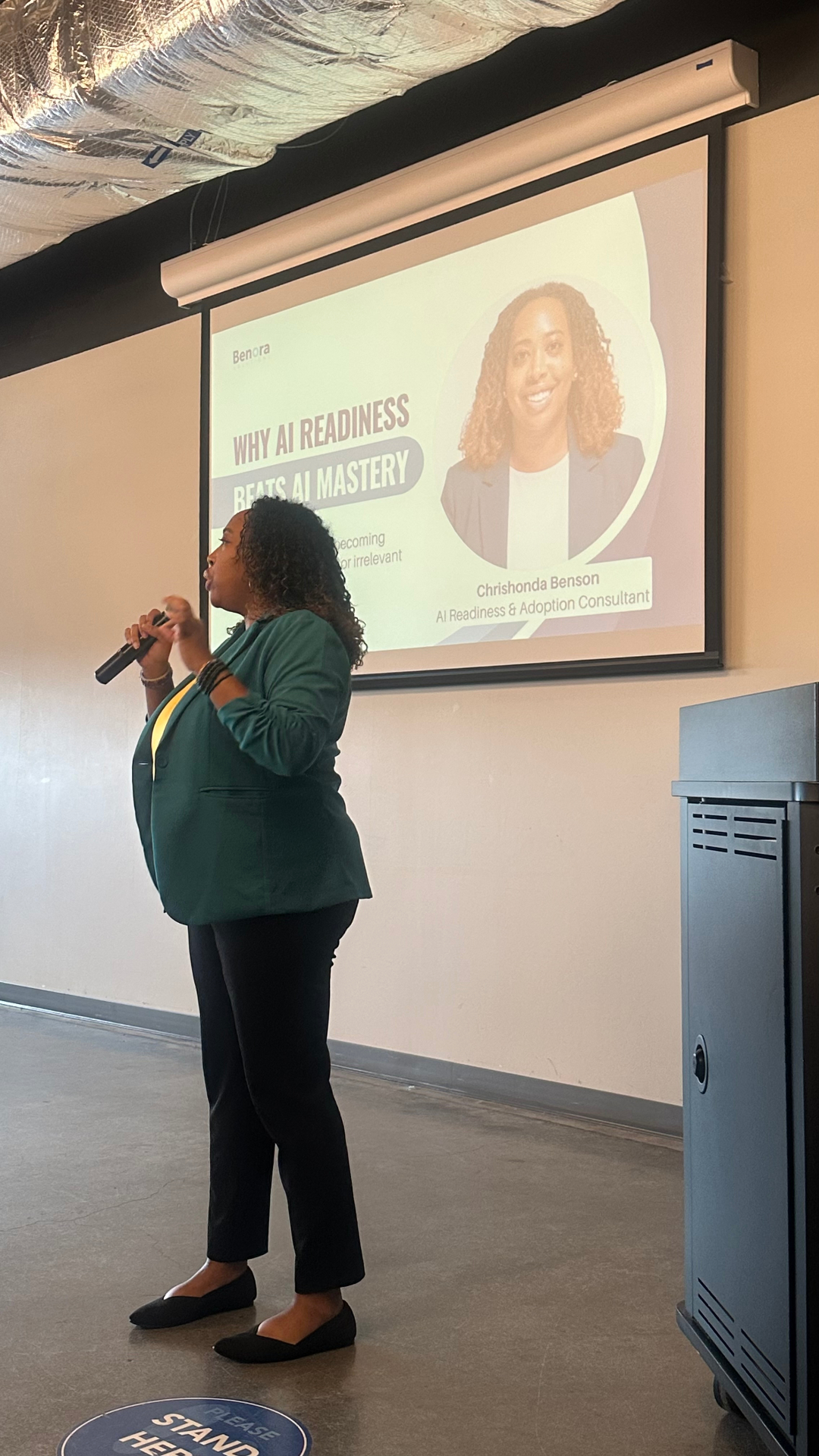 Chrishonda Benson speaking on stage to a conference audience